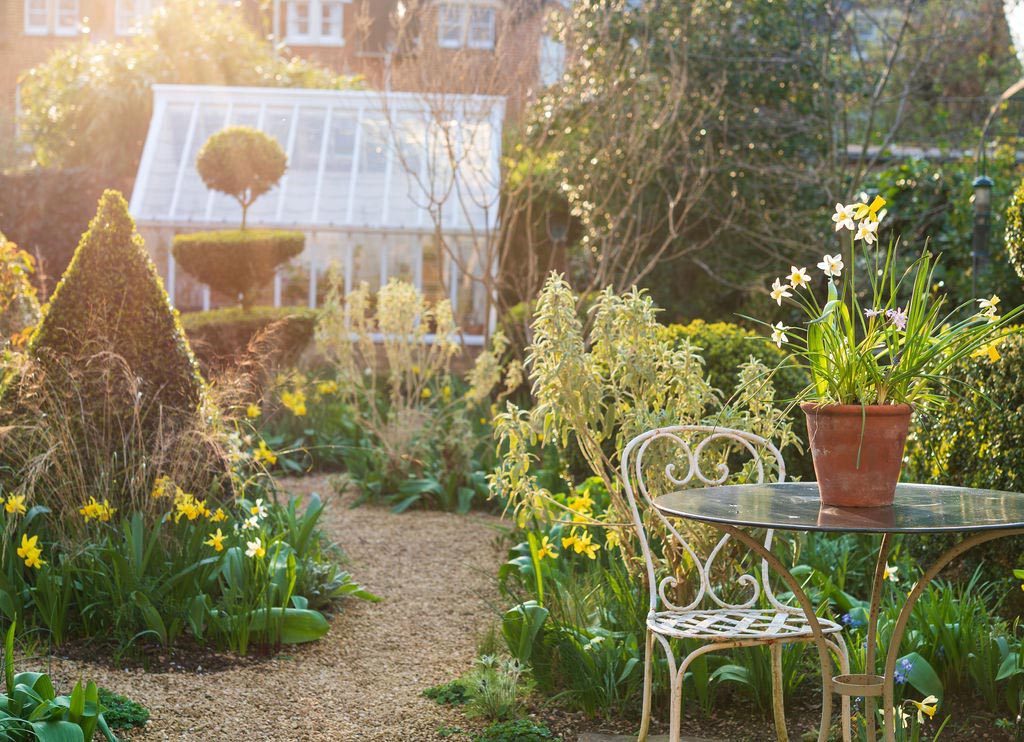 Oxford garden design with topiary, antique French café table, spring flowers and a traditional greenhouse.